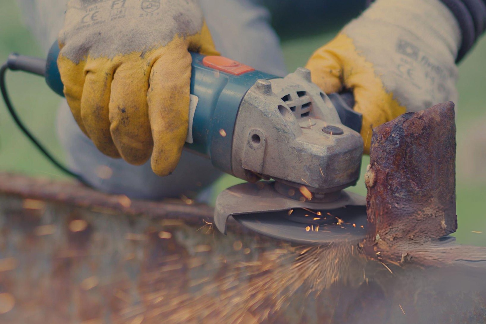 Hero image of an angle grinder cutting steel with sparks, speed/RPM overlay, and safety gear icons