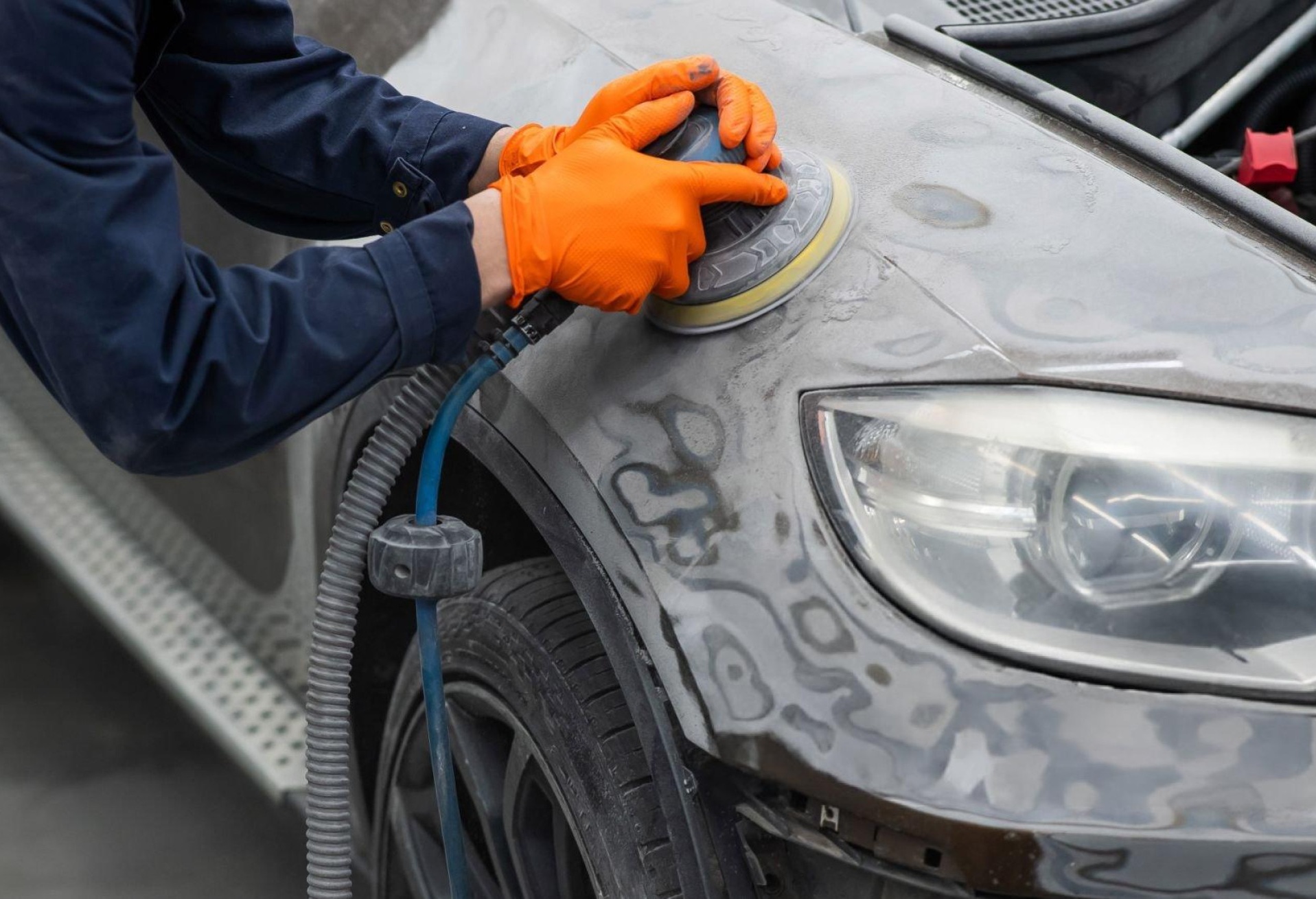 Arabanın kapı panelinin DA zımpara makinesiyle zımparalandığını, kum taneciklerinin yerleştirildiğini ve güvenlik donanımının hazır olduğunu gösteren temiz atölye görüntüsü