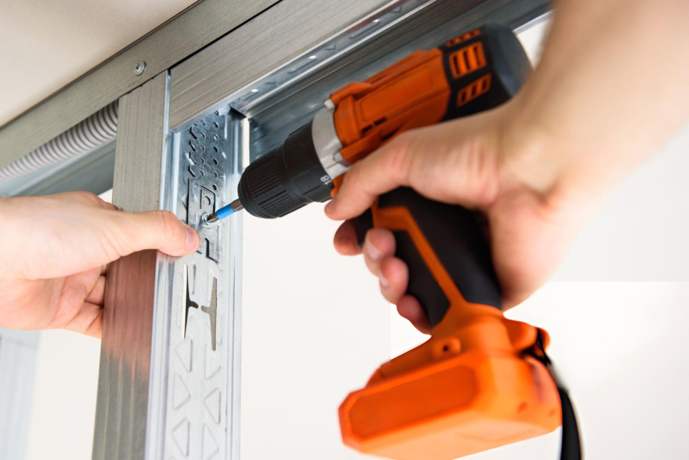 Professional using drywall screw gun to install gypsum board with perfect flush screw depth setting