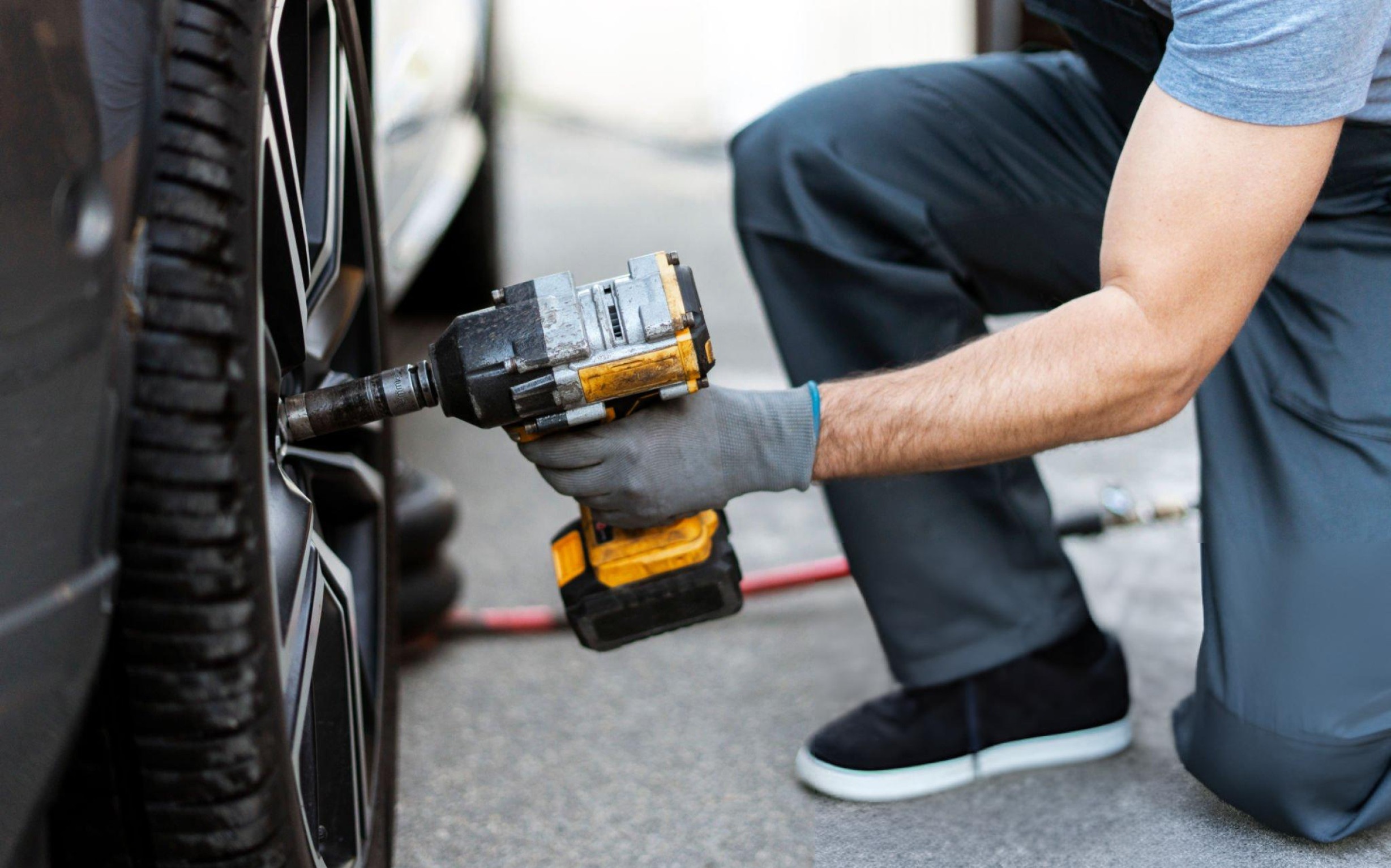 Pneumatic, corded, and cordless impact wrenches with impact sockets in a workshop