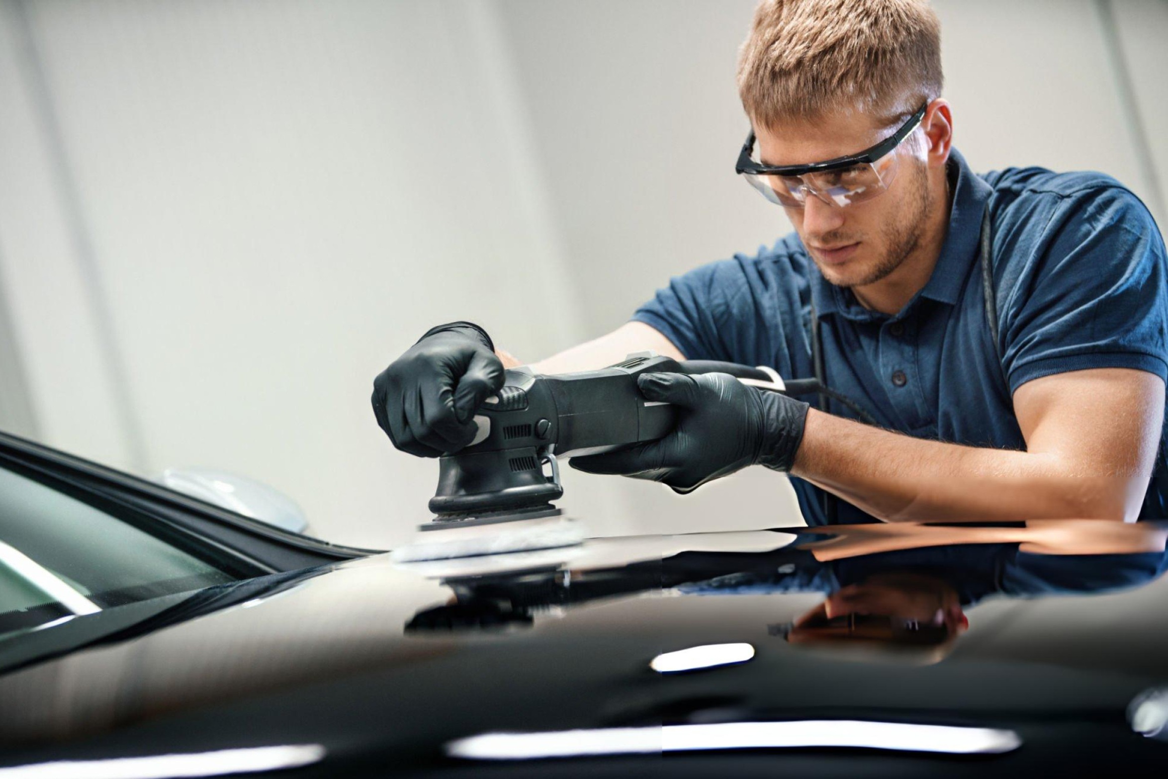 Three main types of automotive polishers (rotary, dual-action, and orbital) displayed on glossy car surface demonstrating professional paint correction equipment